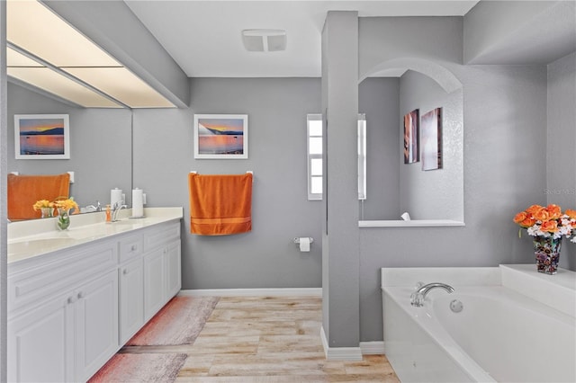 bathroom featuring vanity, hardwood / wood-style flooring, and a bathing tub