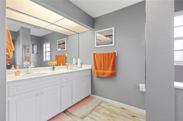 4077 La Costa Island Ct, Punta Gorda, FL 33950 - bathroom with double vanity, a sink, baseboards, and wood finished floors