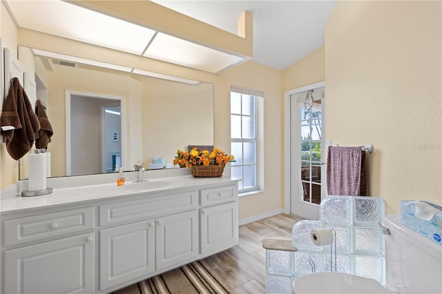 4077 La Costa Island Ct, Punta Gorda, FL 33950 - bathroom featuring vanity, visible vents, lofted ceiling, wood finished floors, and toilet