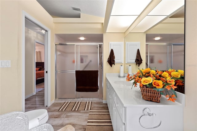 bathroom featuring a shower with door, vanity, wood-type flooring, and lofted ceiling