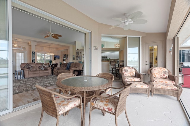 sunroom / solarium featuring ceiling fan, a healthy amount of sunlight, and lofted ceiling