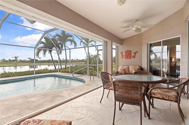 view of pool with a water view, ceiling fan, a lanai, and a patio area