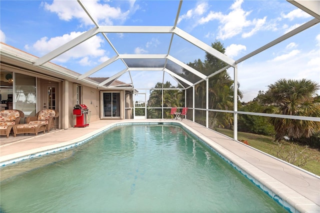 view of swimming pool featuring a patio and glass enclosure