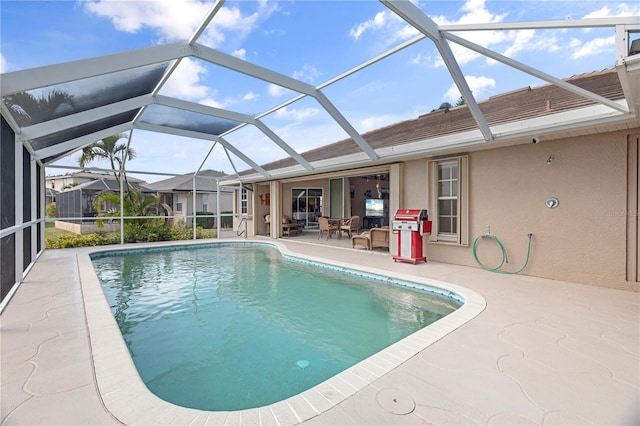 view of swimming pool with a patio area and glass enclosure