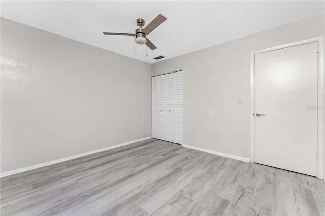 unfurnished bedroom with light hardwood / wood-style flooring, a closet, and ceiling fan