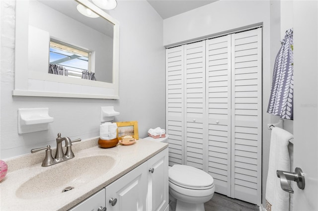 bathroom with vanity, hardwood / wood-style flooring, and toilet