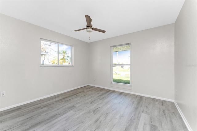 empty room with light wood-type flooring, a healthy amount of sunlight, and ceiling fan