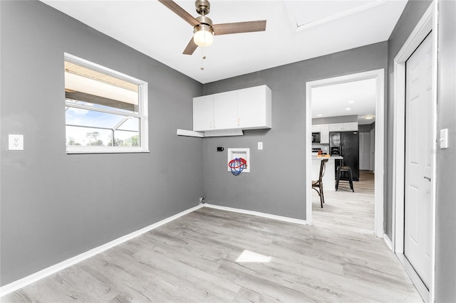 laundry area featuring ceiling fan, electric dryer hookup, cabinets, and light hardwood / wood-style flooring