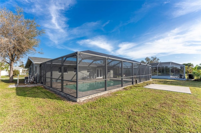 view of swimming pool with a yard, a patio, and a lanai