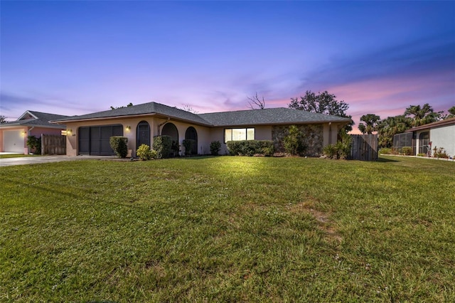 ranch-style home featuring a yard and a garage