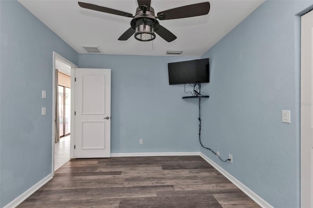 unfurnished bedroom with ceiling fan and dark hardwood / wood-style flooring