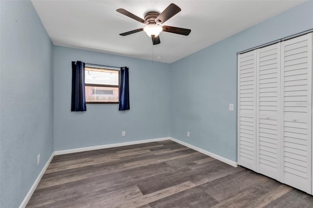 unfurnished bedroom featuring a closet, ceiling fan, and dark hardwood / wood-style flooring