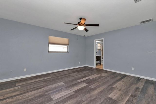 spare room with dark wood-type flooring and ceiling fan