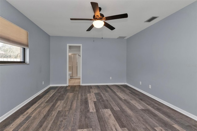 spare room with dark wood-type flooring and ceiling fan