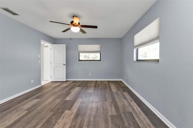 spare room featuring dark wood-type flooring and ceiling fan