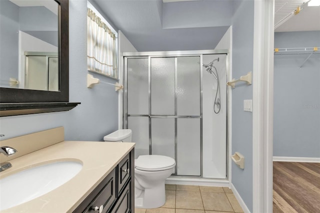 bathroom featuring vanity, toilet, walk in shower, and hardwood / wood-style floors