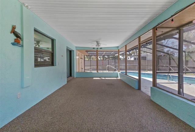 unfurnished sunroom featuring ceiling fan