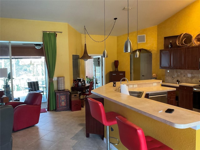 kitchen with dishwasher, sink, backsplash, a kitchen breakfast bar, and a kitchen island with sink