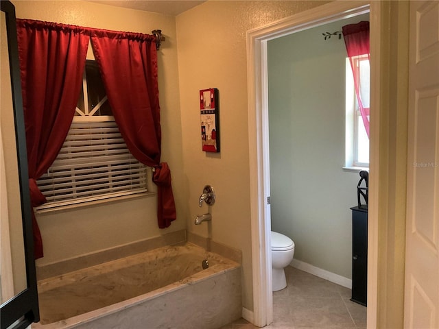 bathroom with toilet, a tub to relax in, and tile patterned flooring