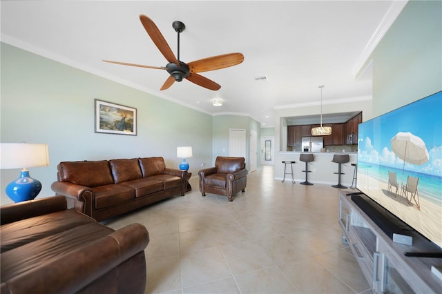 tiled living room with ceiling fan and crown molding