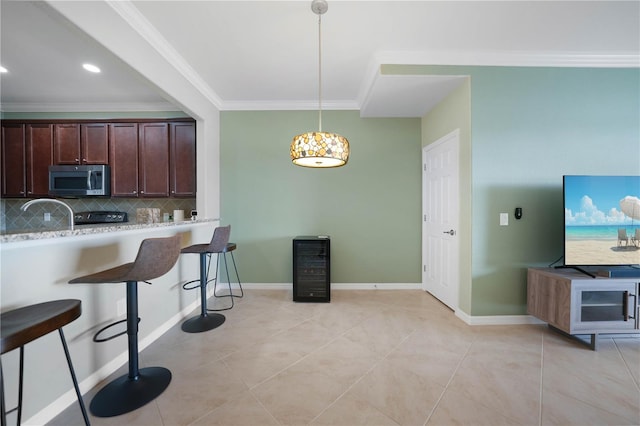 kitchen featuring a breakfast bar, hanging light fixtures, decorative backsplash, light tile patterned floors, and dark brown cabinetry