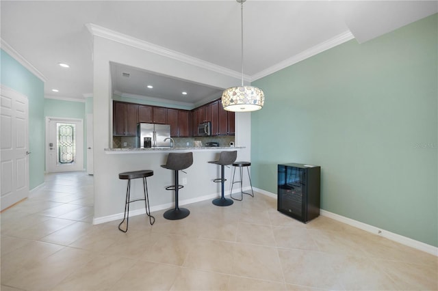 kitchen featuring kitchen peninsula, decorative light fixtures, stainless steel appliances, and ornamental molding