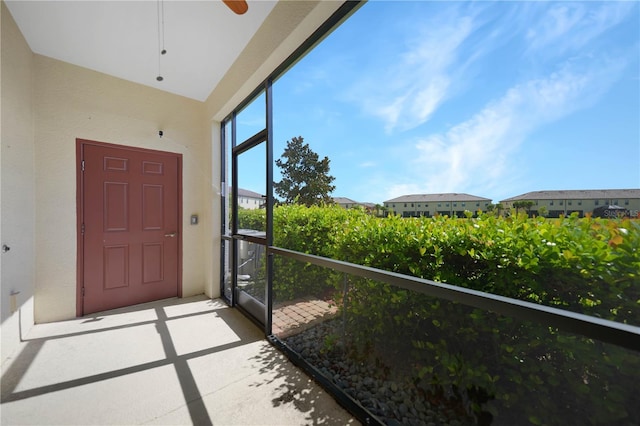 unfurnished sunroom with ceiling fan