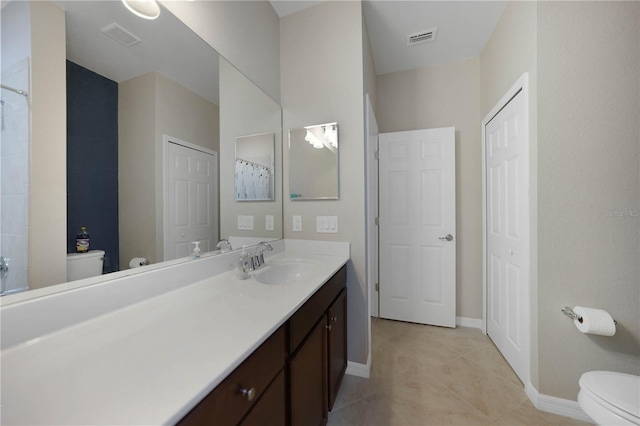 bathroom with tile patterned flooring, vanity, and toilet