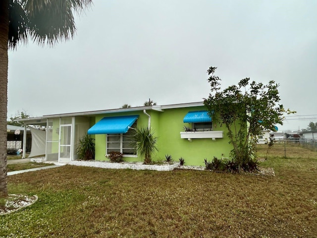 exterior space featuring a front lawn and a sunroom