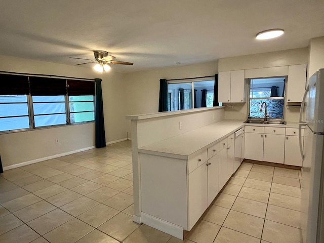 kitchen featuring sink, white appliances, white cabinetry, and plenty of natural light