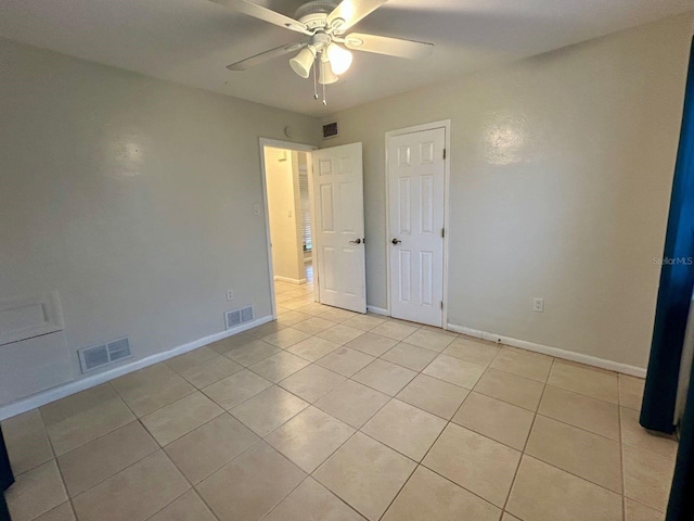 unfurnished bedroom with light tile patterned floors and ceiling fan