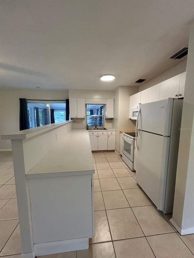 kitchen featuring white cabinetry, sink, white appliances, and light tile patterned floors