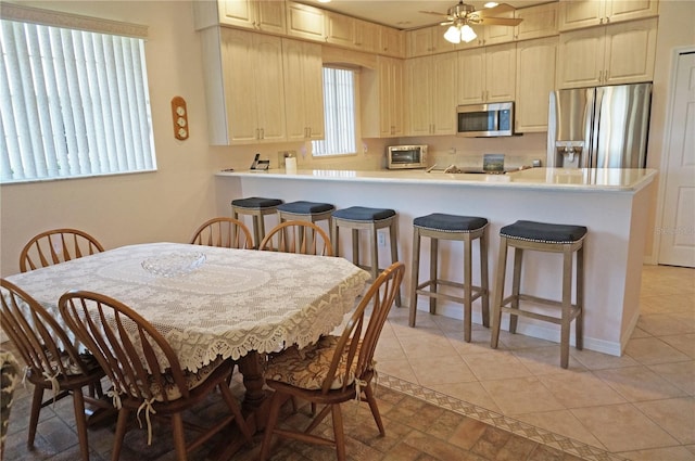 tiled dining room featuring ceiling fan