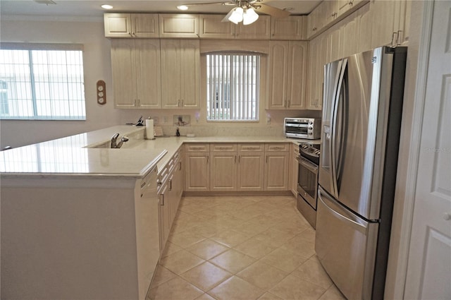 kitchen with light brown cabinetry, a healthy amount of sunlight, appliances with stainless steel finishes, and kitchen peninsula