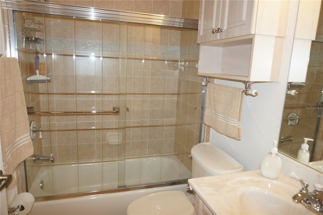 full bathroom featuring vanity, bath / shower combo with glass door, and toilet