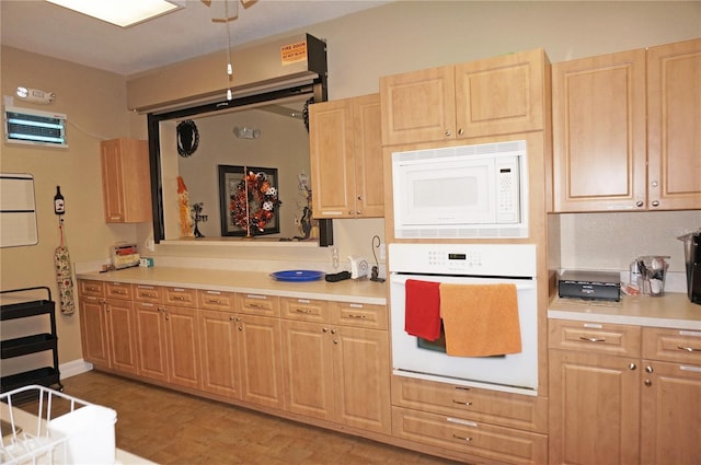 kitchen featuring light brown cabinets, light parquet floors, and white appliances