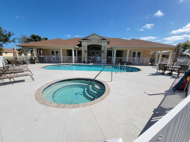 view of swimming pool with a patio and a hot tub