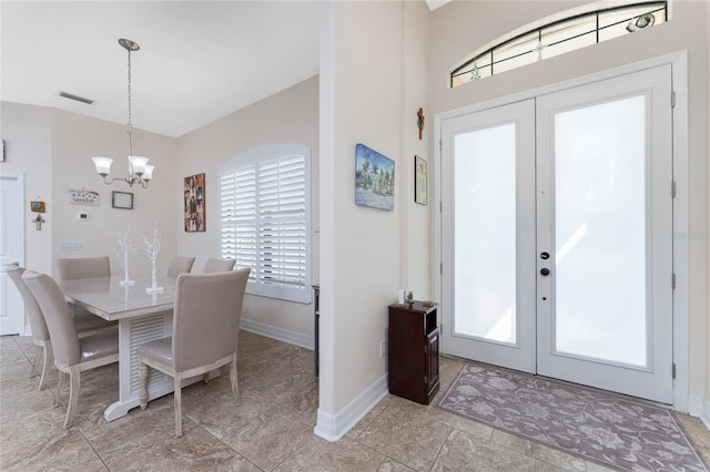 dining space featuring french doors and a notable chandelier