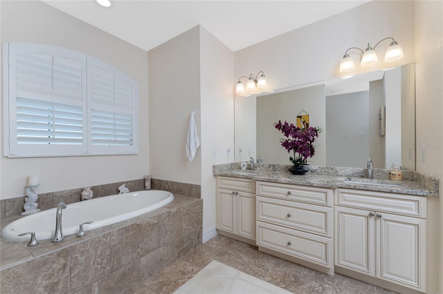 bathroom featuring vanity and tiled tub