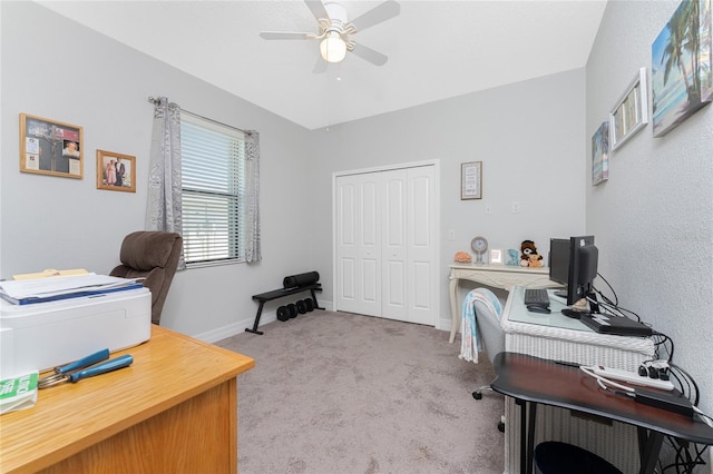 carpeted home office featuring ceiling fan