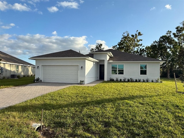 single story home featuring central AC unit, a front yard, and a garage