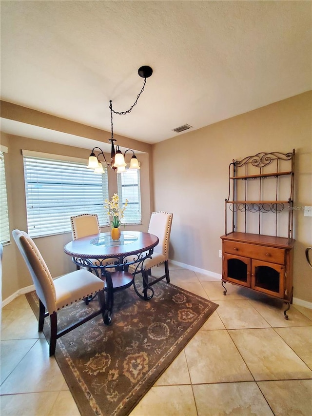 dining space featuring a notable chandelier, light tile patterned floors, and plenty of natural light