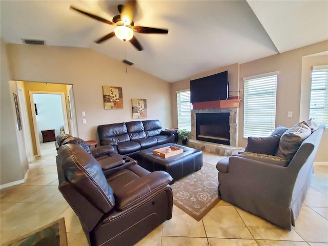 living room with ceiling fan, light tile patterned floors, a fireplace, and vaulted ceiling