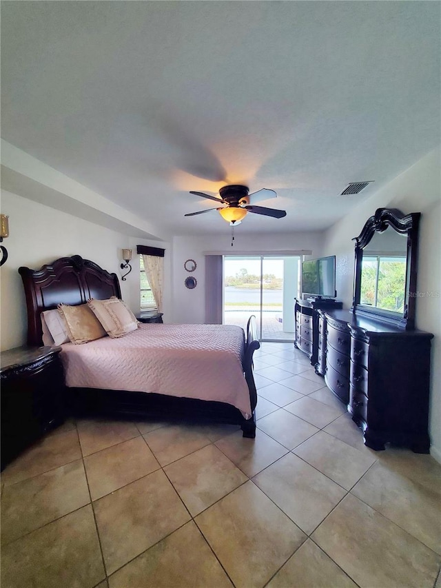 unfurnished bedroom featuring light tile patterned flooring, access to exterior, and ceiling fan