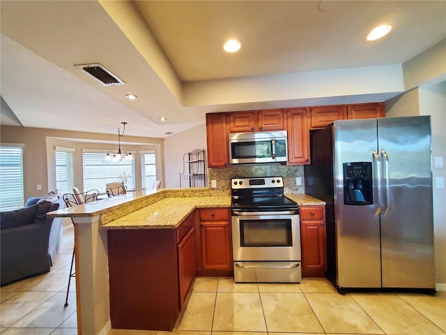 kitchen featuring appliances with stainless steel finishes, kitchen peninsula, hanging light fixtures, and a breakfast bar