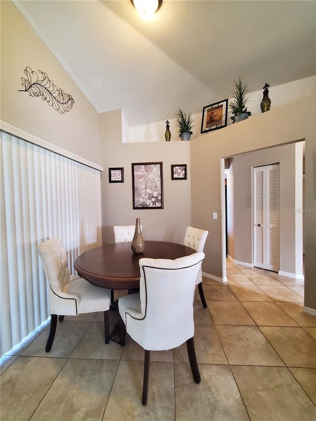 509 Clearview Dr, Port Charlotte, FL 33953 - dining area with lofted ceiling, light tile patterned flooring, and baseboards