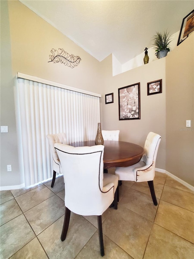 dining room with lofted ceiling and light tile patterned floors