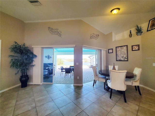 dining room with high vaulted ceiling and light tile patterned floors