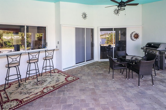 view of patio featuring area for grilling, an outdoor bar, and ceiling fan