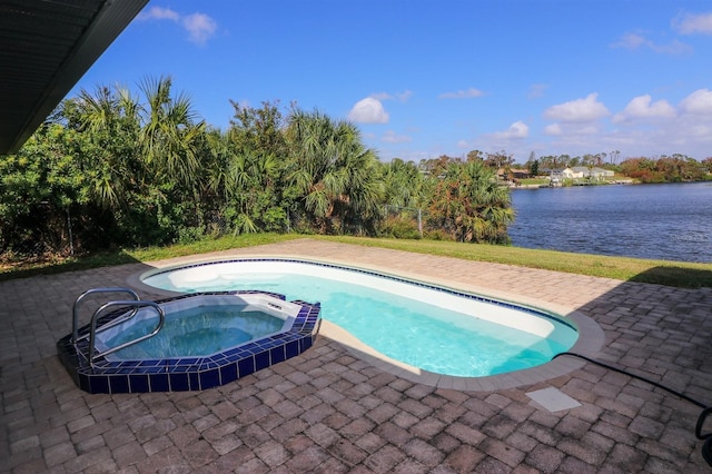 view of pool with a patio area, an in ground hot tub, and a water view